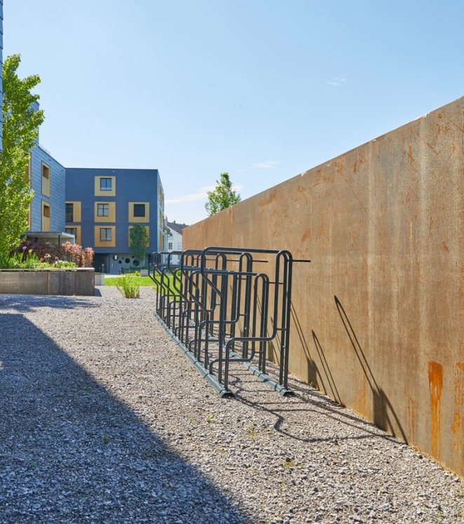 Kiesplatz mit Fahrradständer und Hochbeet